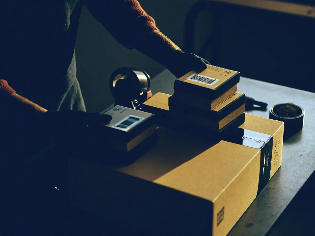 Several small parcels being repacked into one shipping carton